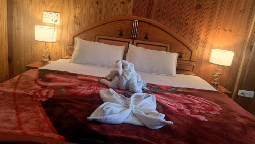 a stuffed animal is laying on a bed at RRR RESORTS TIRTHAN Valley by RRR HOTELS & RESORTS in Banjār