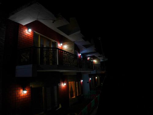 a building with lights on the side of it at night at Vista Suites Doddabetta Ooty By Bestinn Leisure in Ooty