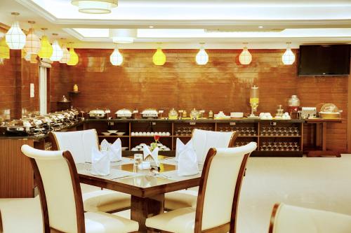 a dining room with a table and chairs and a bar at The Liverpool Blue Hotels in Bengaluru