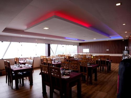 a dining room with tables and chairs and a red ceiling at Vista Peak View Ooty in Ooty