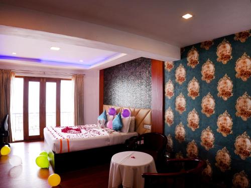 a bedroom with a bed and a table in it at Vista Suites Doddabetta Ooty By Bestinn Leisure in Ooty