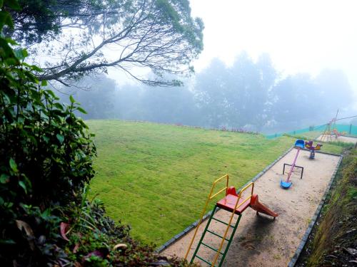 a playground with a slide in a field at Vista Suites Doddabetta Ooty By Bestinn Leisure in Ooty
