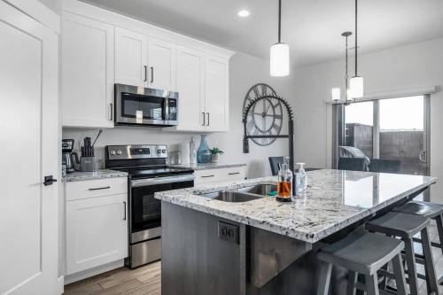 a kitchen with white cabinets and a granite counter top at St George, private hot tub/patio, new community in Washington