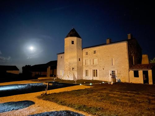 un vieux bâtiment la nuit avec la lune dans le ciel dans l'établissement Logis de Pierre Levée, à Bessines