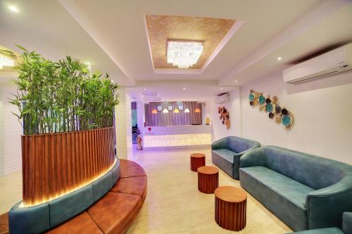 a living room with two couches and a large plant at The Liverpool Blue Hotels in Bengaluru