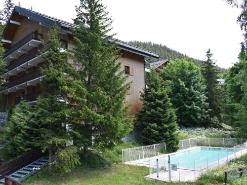 un complexe avec une piscine et un bâtiment dans l'établissement Méribel Studio 4 pers - Piscine, Ski aux pieds, Centre, Balcon Sud - FR-1-180-18, à Méribel