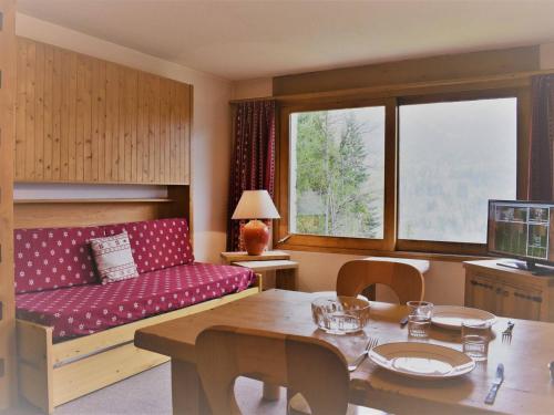 een woonkamer met een rode bank en een tafel bij Appartement Méribel, 1 pièce, 3 personnes - FR-1-180-21 in Méribel