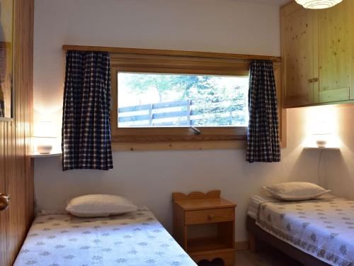 une chambre avec deux lits jumeaux et une fenêtre dans l'établissement Appartement Cozy pour 6 à Méribel, 2 Chambres, Parking, Proche Télésiège - FR-1-180-573, à Les Allues