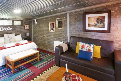 - un salon avec un canapé et un lit dans l'établissement Gods Gift cottage and Mattaniah Cottage, à Clarens