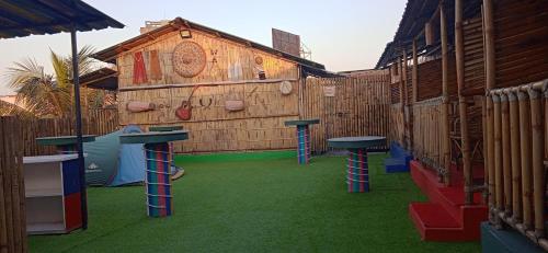 a playground with two tables and a wooden building at Tridhara HomeStay in Guwahati