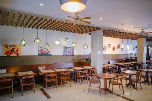 una sala da pranzo con tavoli e sedie in legno di Biz Hotel Ambon a Ambon