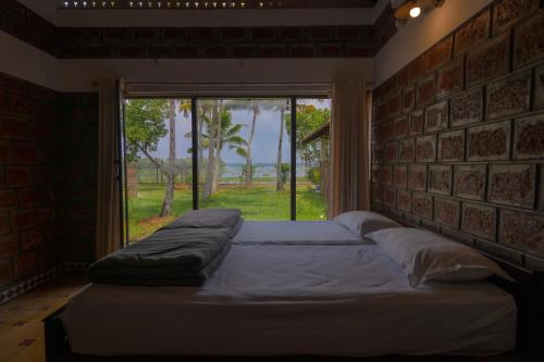 ein großes Bett in einem Zimmer mit Fenster in der Unterkunft Ekantha Ala in Murinjupuzha