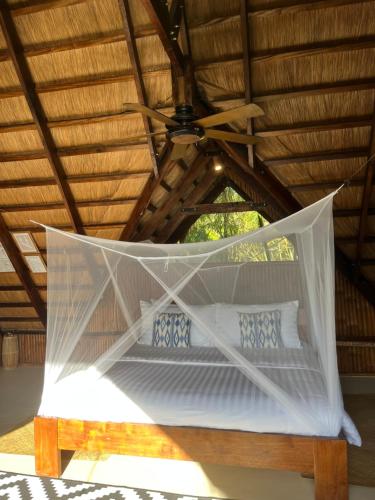 a bed in a room with a ceiling at The Beach House Ocam Ocam in Busuanga