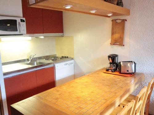 - une cuisine avec une table en bois et une cafetière dans l'établissement Duplex rustique avec grande terrasse au Sud, proche vieux Val-d'Isère - FR-1-694-310, à Val dʼIsère