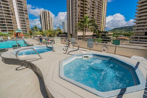 a swimming pool with a hot tub on a building at Pool & Jacuzzis, Free Parking, WiFi, AC, Comfy Beds, BBQ, and Great View in Honolulu