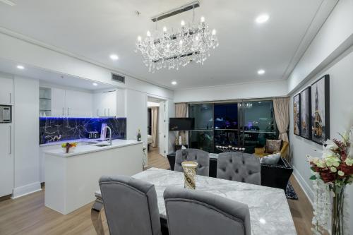 a dining room and living room with a chandelier at Extravagant Escape in Auckland