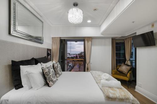 a bedroom with a large white bed and a window at Extravagant Escape in Auckland