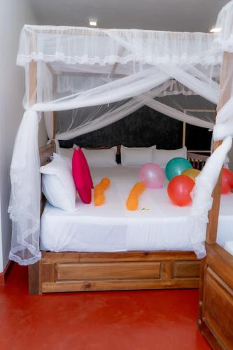 a bed with a canopy with balloons on it at Rainforest Holiday Inn in Deniyaya