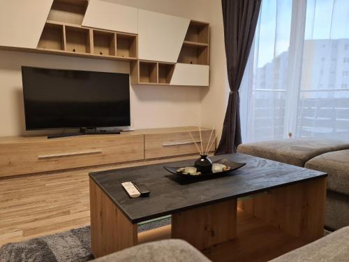 a living room with a television and a coffee table at OSCAR HOUSE in Braşov