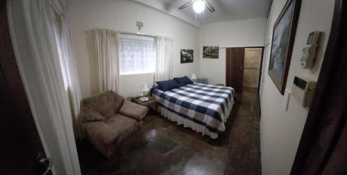ein Schlafzimmer mit einem Bett, einem Stuhl und einem Fenster in der Unterkunft Rilli's Inn Apartment in Mtunzini