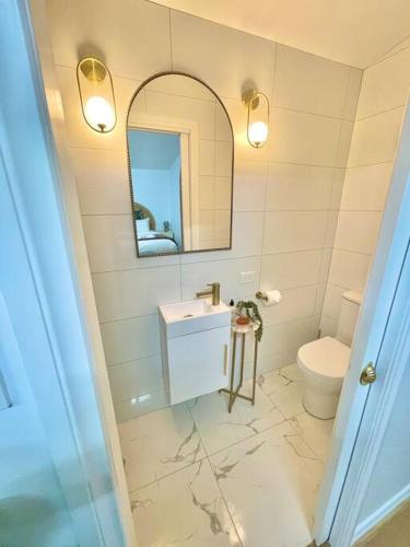 a bathroom with a sink and a toilet and a mirror at • Cottage 1851 • Boutique in Brown Hill in Gong Gong