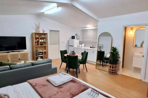 a living room with a couch and a table and a kitchen at • Cottage 1851 • Boutique in Brown Hill in Gong Gong