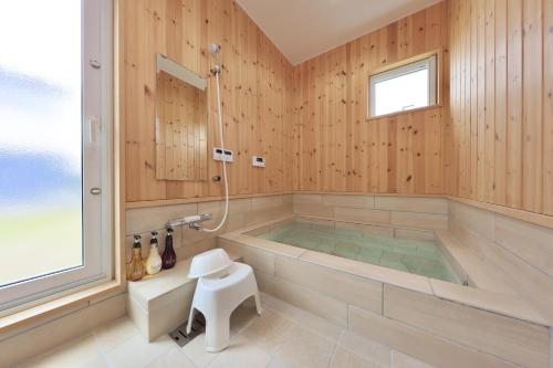 a large bathroom with a tub and a shower at Crystal Besso Uminomachi in Shirahama