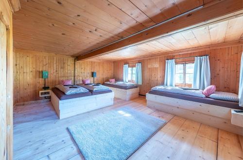a room with three beds in a wooden cabin at Großmutters Haus in Westendorf