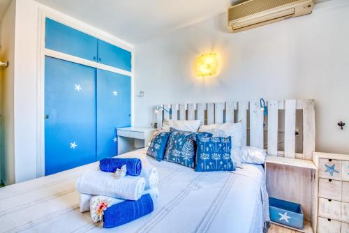 a bedroom with a large white bed with blue pillows at Ideal Property Mallorca - Mas i Reus 10 in Alcudia