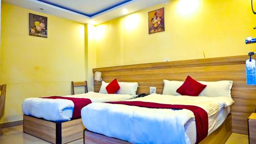 two beds in a hotel room with red and white pillows at HOTEL STAR HOLIDAY PVT LTD in Bhairāhawā