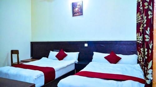 a hotel room with two beds with red pillows at HOTEL STAR HOLIDAY PVT LTD in Bhairāhawā