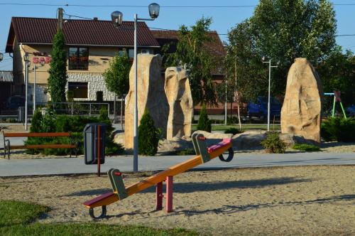 a playground with a slide in front of some rocks at Vila Sara in Chişoda