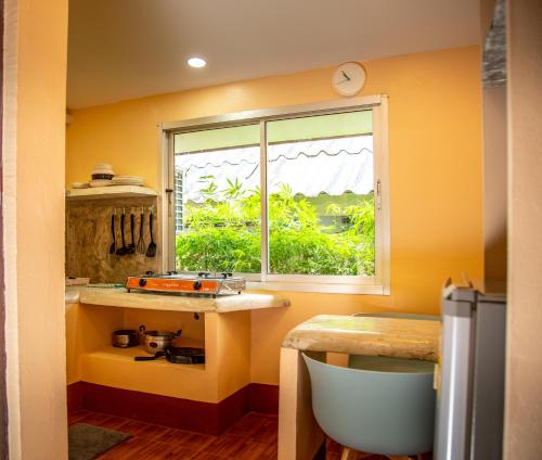 a yellow kitchen with a window and a table at Filou Studio Butterfly Pool Access 29 66 in Ko Chang