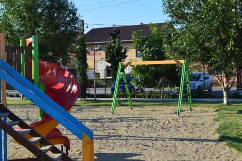 a playground with colorful swings in a park at Vila Sara in Chişoda