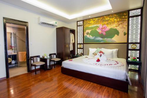 a bedroom with a bed with a flower on it at Thanh Lich Hue Hotel in Hue