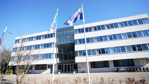 a building with two flags in front of it at Amrâth Apart-Hotel Schiphol Badhoevedorp in Badhoevedorp