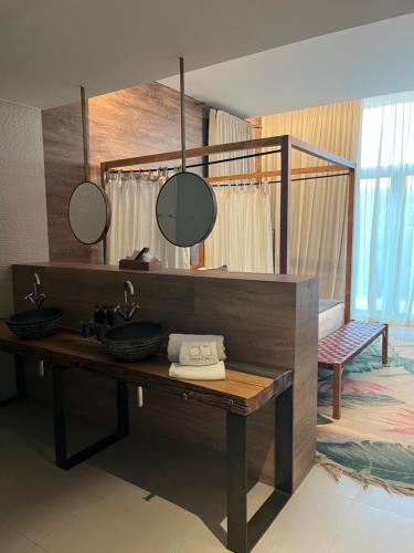 a bathroom with a vanity with a sink and mirrors at Playa Grande by Tropical - Adults Only in Gavà
