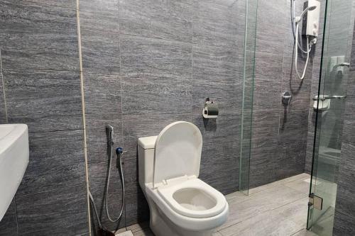 a bathroom with a toilet and a glass shower stall at Cinema Blue Ocean 3 bedroom house kids water park in Shah Alam