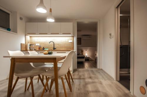 a kitchen and dining room with a table and chairs at Cozy Little Apartments in Ig