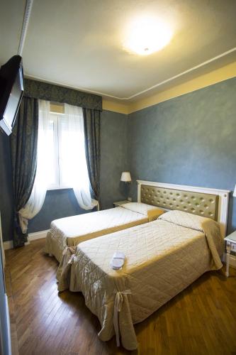 a bedroom with two beds and a window at Hotel Gennarino in Livorno