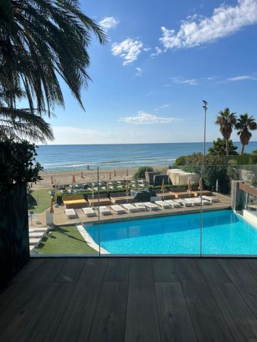 a swimming pool with a view of the ocean at Playa Grande by Tropical - Adults Only in Gavà
