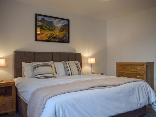 a bedroom with a large bed with a picture on the wall at Pickle House in Newport-On-Tay