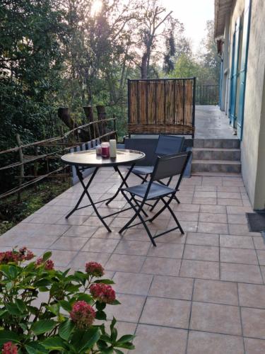 un patio avec une table et des chaises sur un patio dans l'établissement Entre Dordogne et Charente en Nouvelle Aquitaine, à Porchères