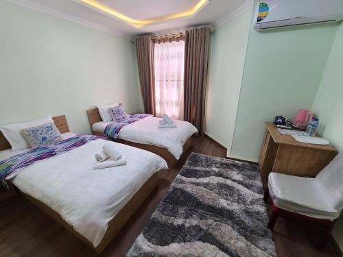 two beds in a small room with a window at Samarkand City Center Hotel in Samarkand