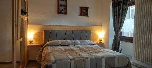a bedroom with a large bed with two lamps at Galanthus in Aosta