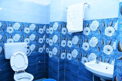 a blue tiled bathroom with a toilet and a sink at HOTEL DREAM PALACE in Puri
