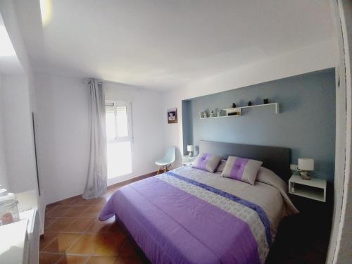 um quarto com uma cama roxa com almofadas roxas em Aquamarina sea view em Benalmádena