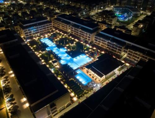 an overhead view of a building with a swimming pool at night at Courtyard Long Beach Holiday Resort in Iskele