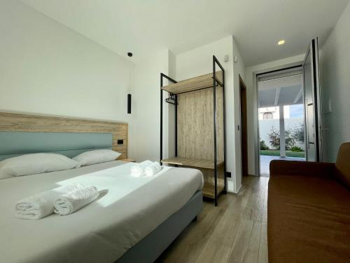 een slaapkamer met een groot bed en handdoeken bij Bari Airport Rooms in Bari