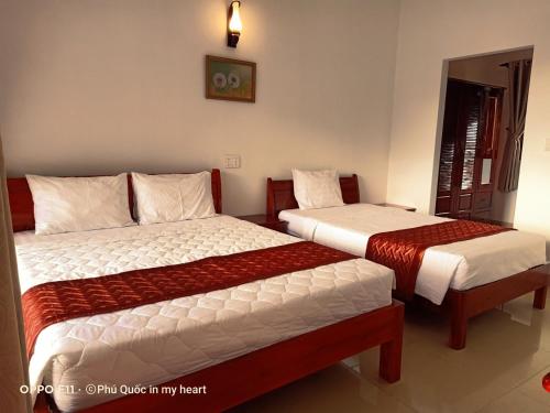two beds in a hotel room with at Hong Bin Bungalow in Phu Quoc
